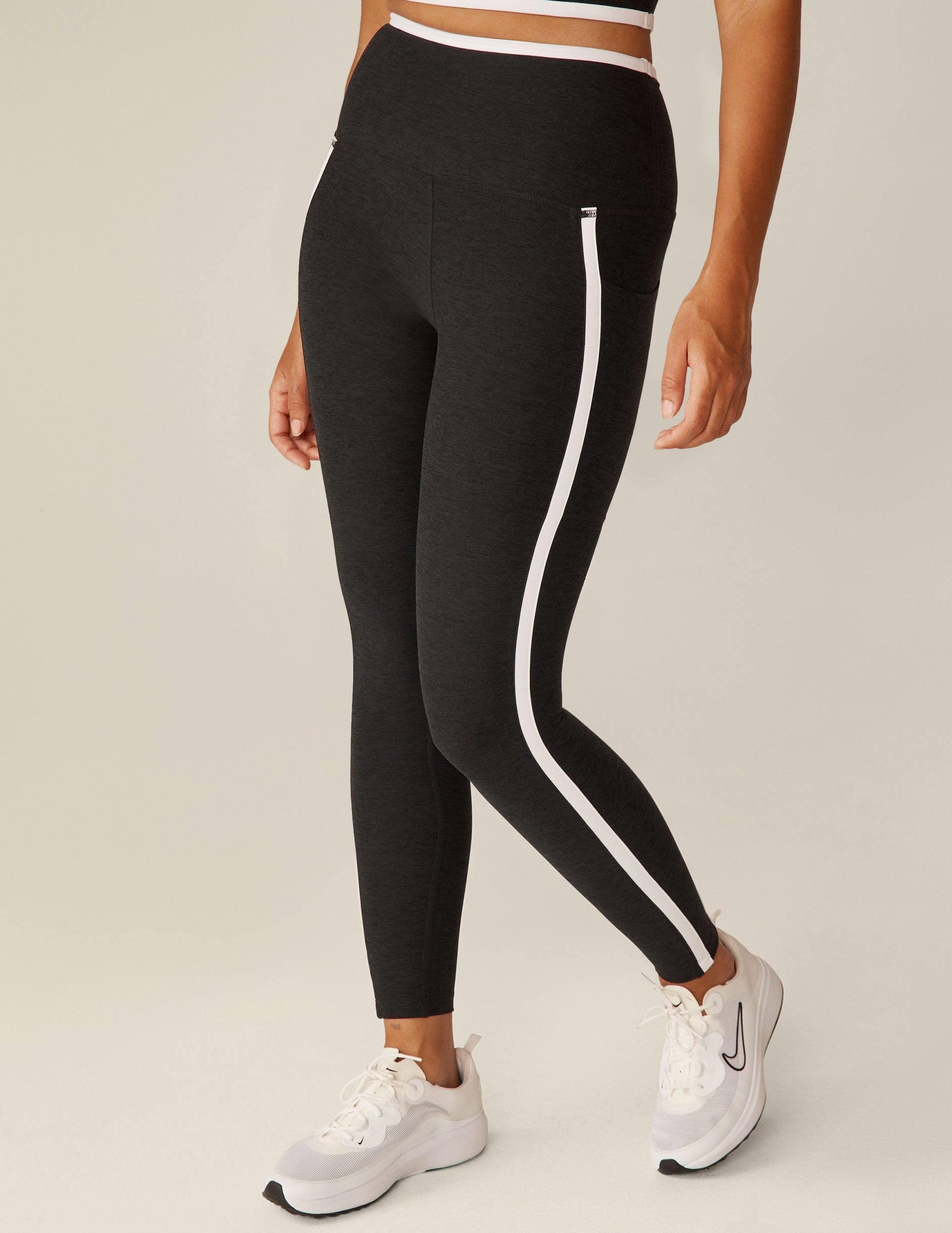black pocket high-waisted midi legging with white lining around waistband and down the sides.