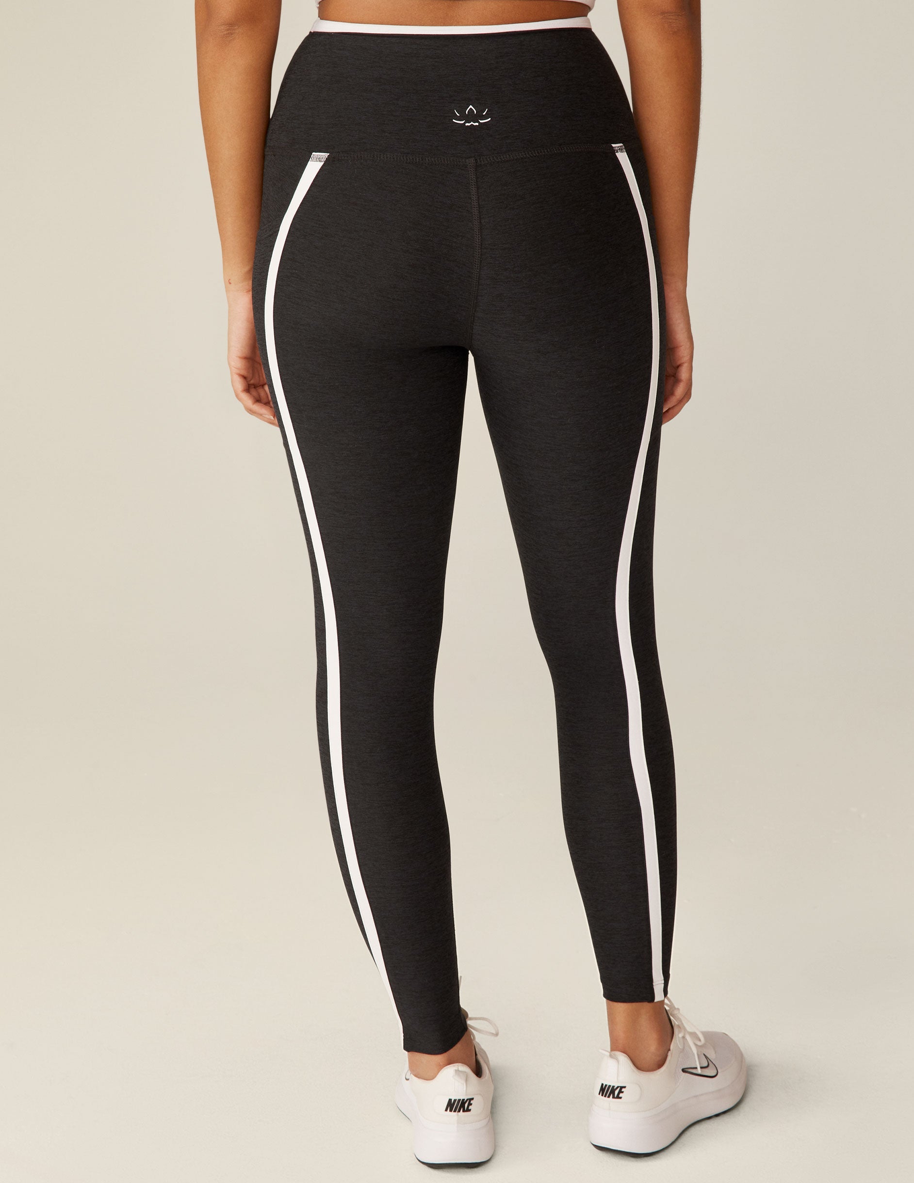 black pocket high-waisted midi legging with white lining around waistband and down the sides.