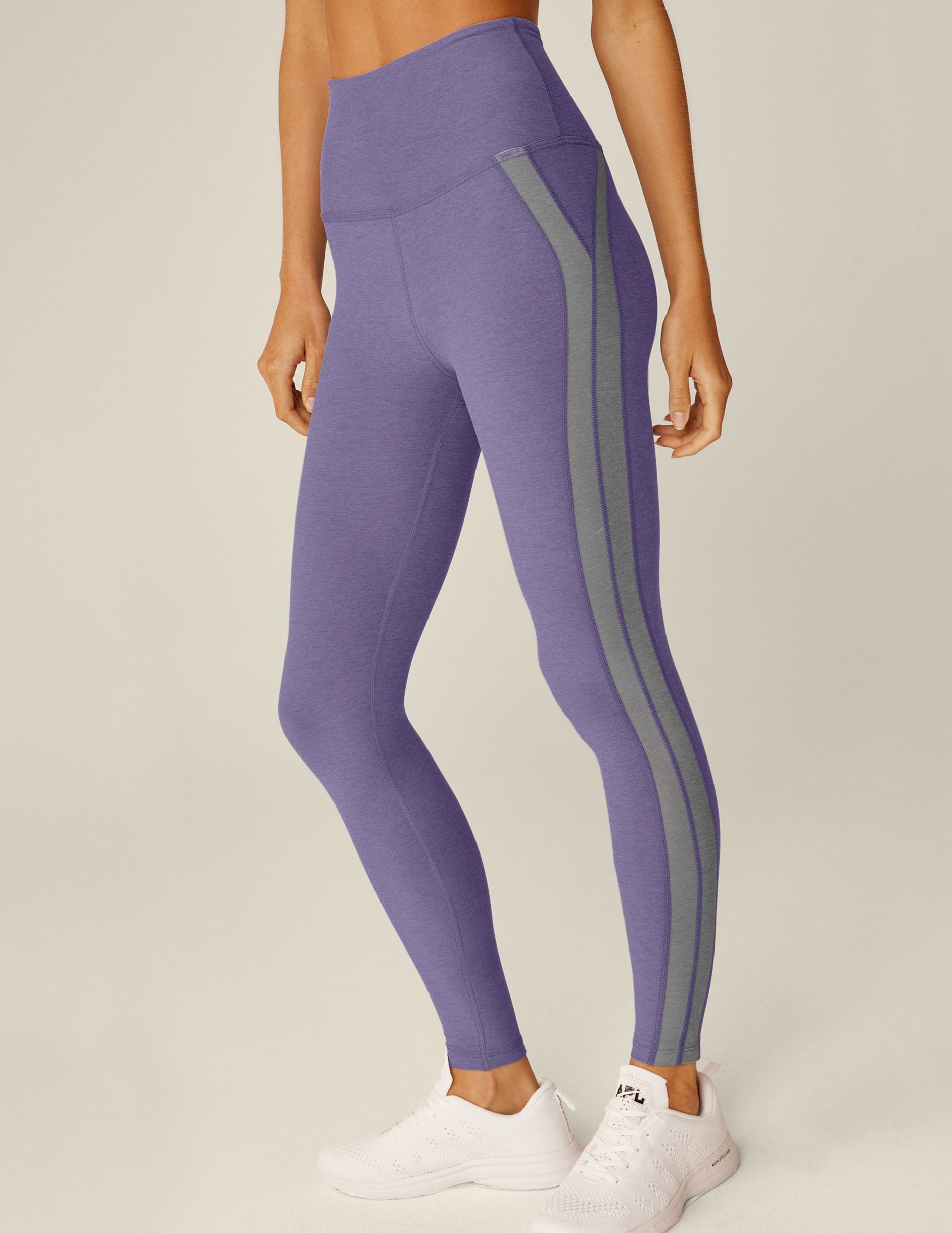 purple high-waisted midi leggings with gray trim down the side.