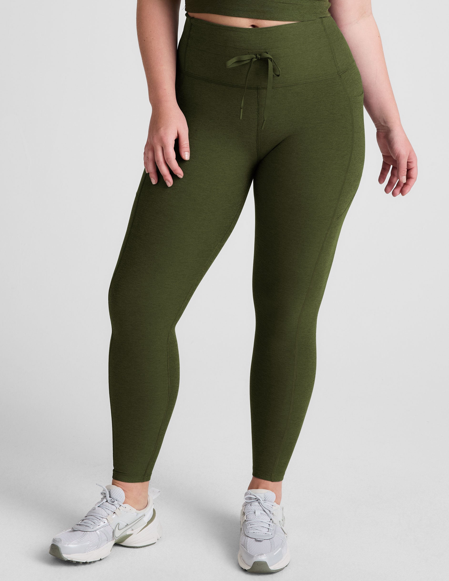 green high-waisted midi length leggings with pockets and a drawstring at waistband.