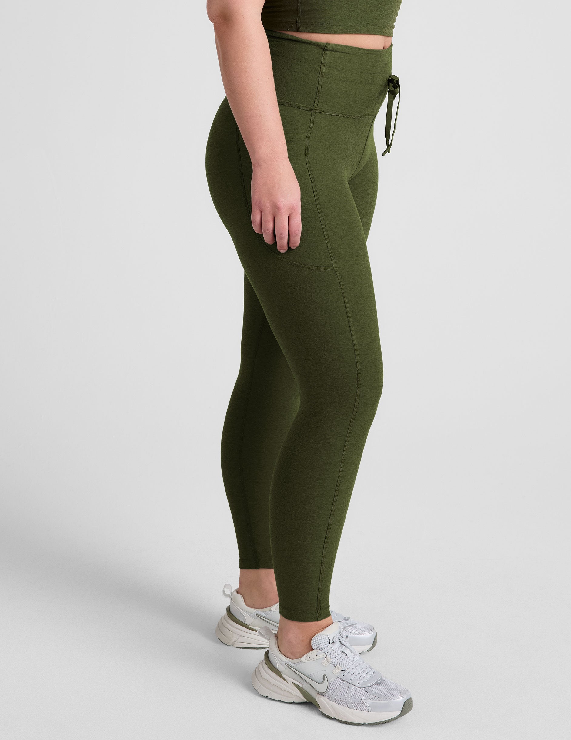 green high-waisted midi length leggings with pockets and a drawstring at waistband.