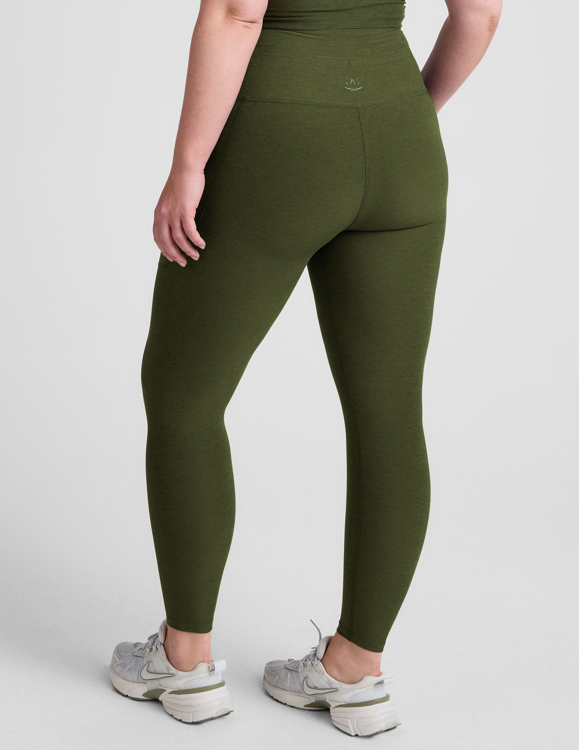 green high-waisted midi length leggings with pockets and a drawstring at waistband.