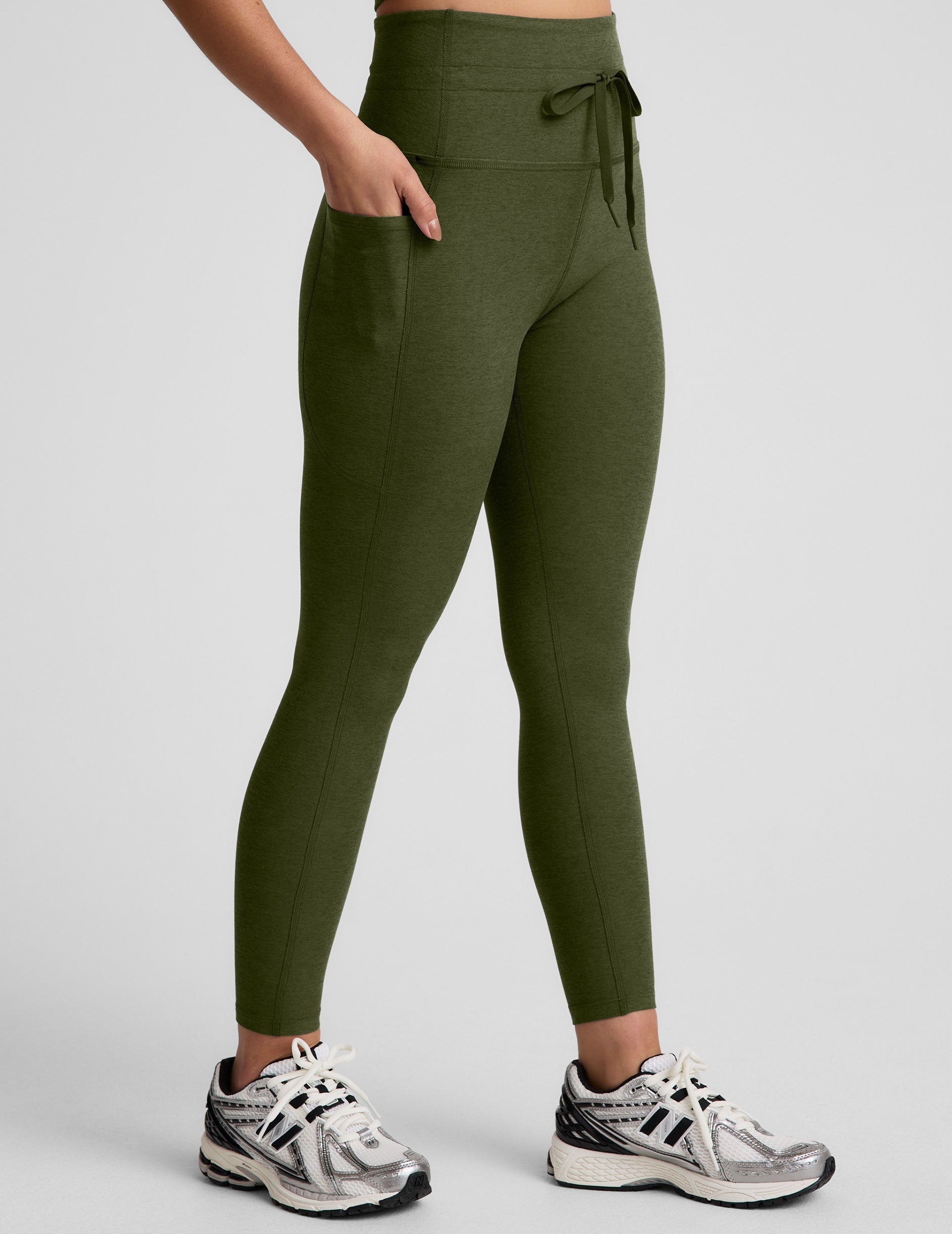 green high-waisted midi length leggings with pockets and a drawstring at waistband.