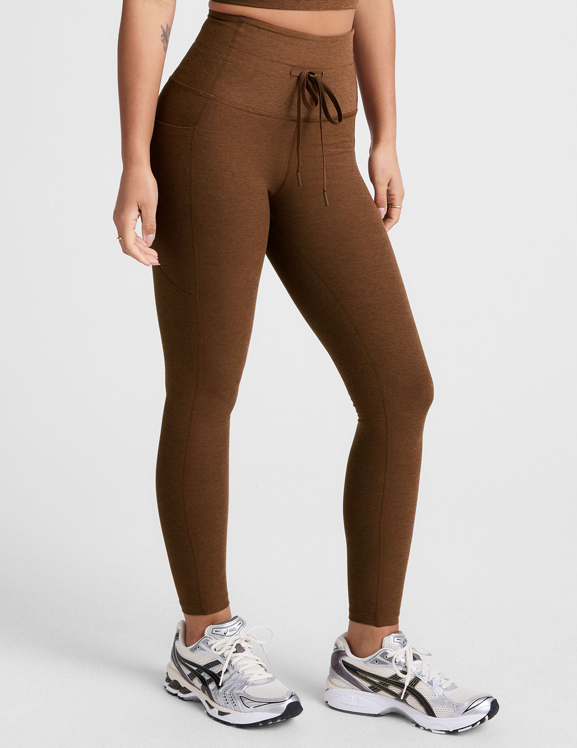 brown high-waisted midi length leggings with a drawstring at waistband and side pockets.