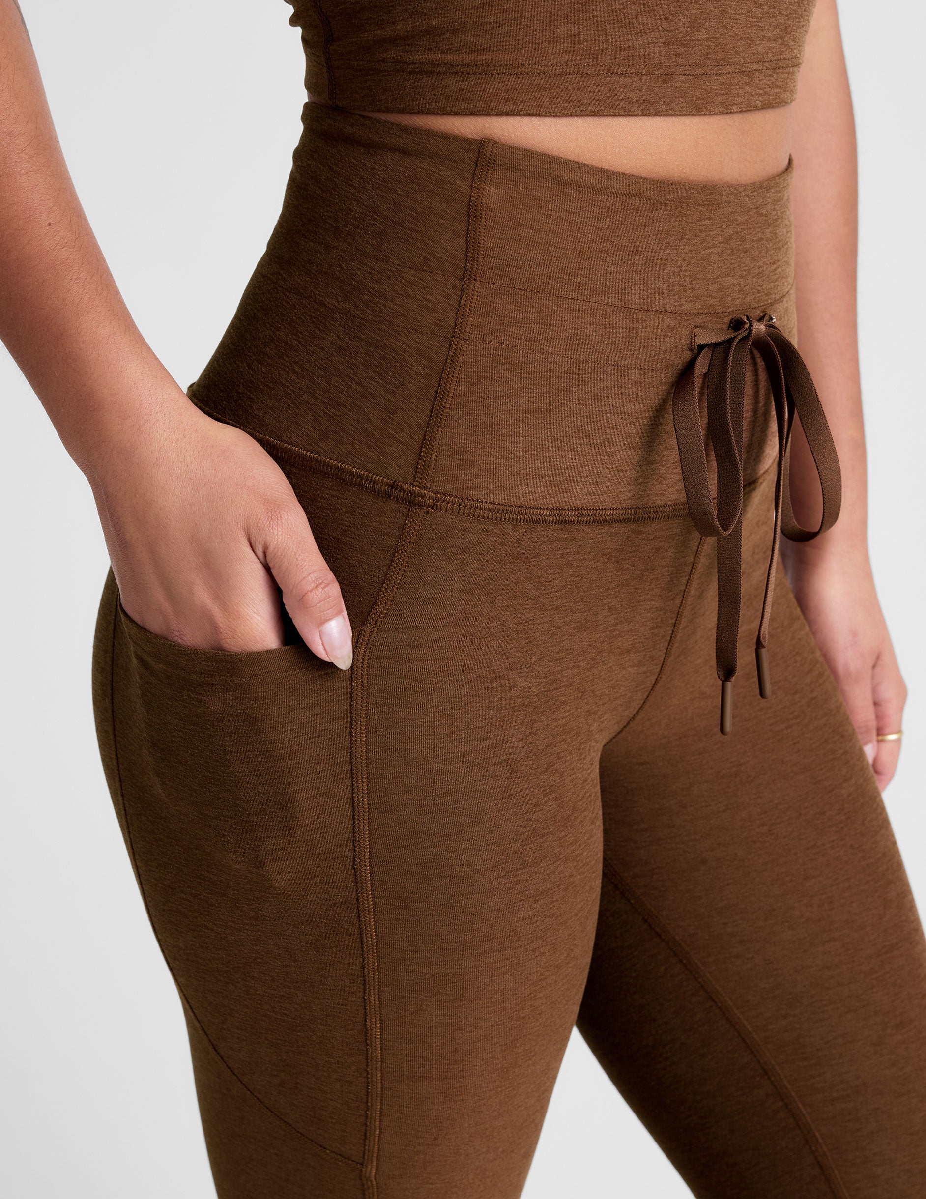 brown high-waisted midi length leggings with a drawstring at waistband and side pockets.