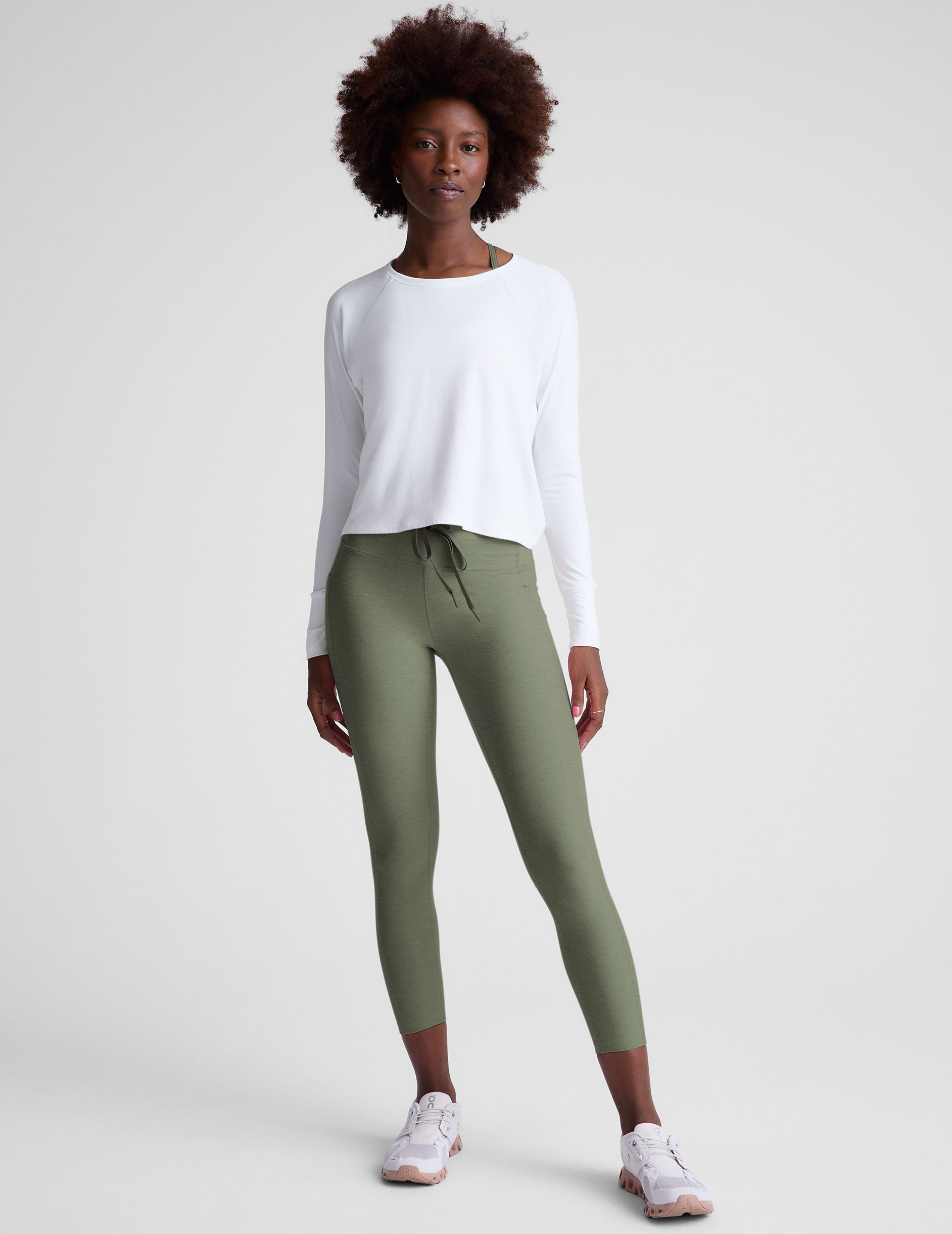 green high-waisted midi length leggings with pockets and a drawstring at waistband.