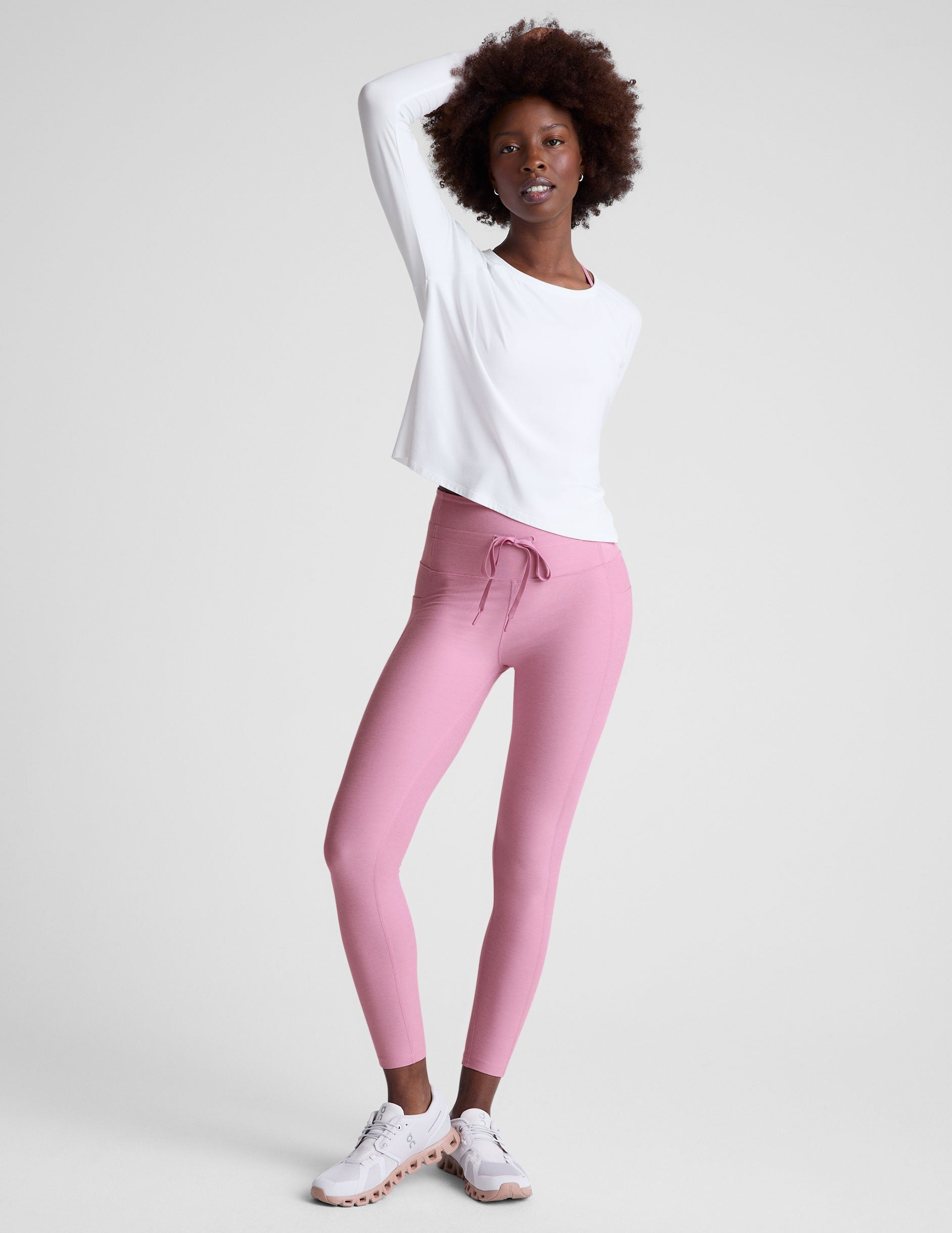 pink high-waisted midi length leggings with a drawstring at the waist and side pockets.