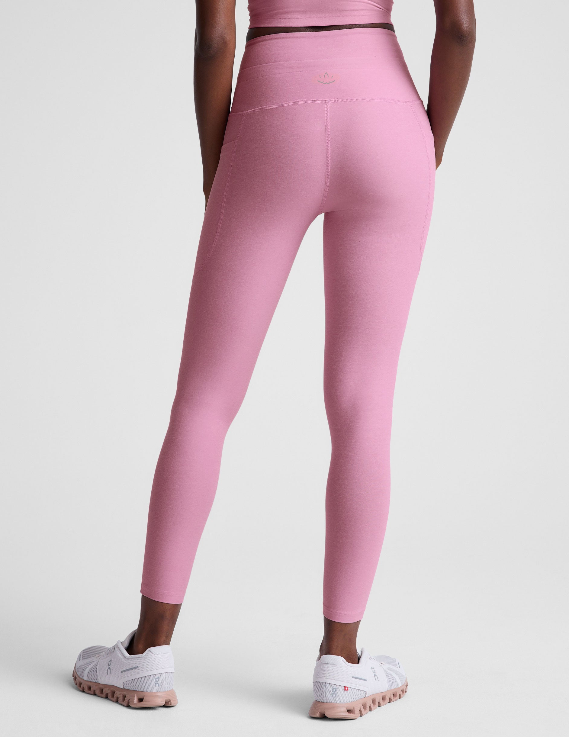 pink high-waisted midi length leggings with a drawstring at the waist and side pockets.