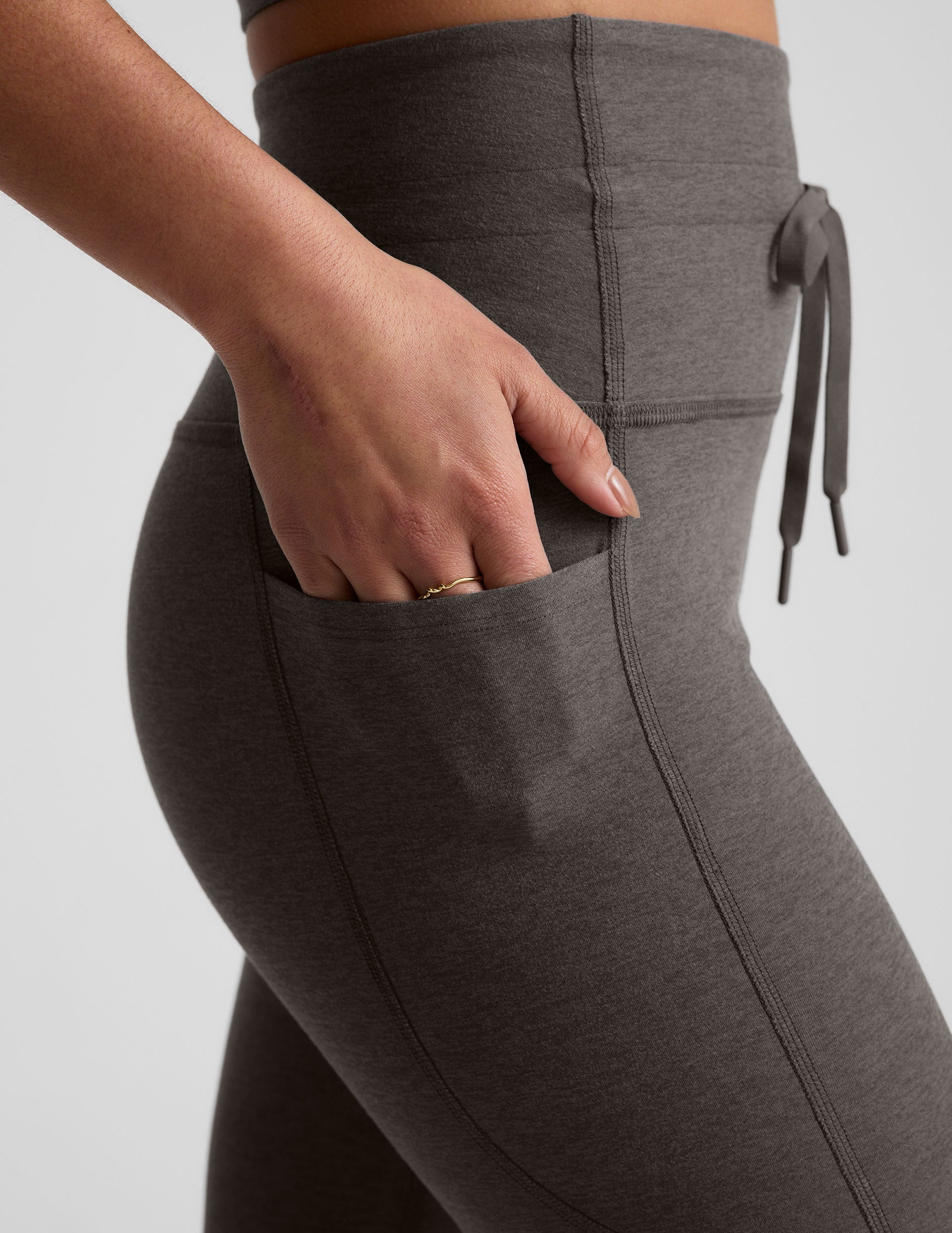 gray high-waisted midi length leggings with a drawstring at waistband and side pockets.