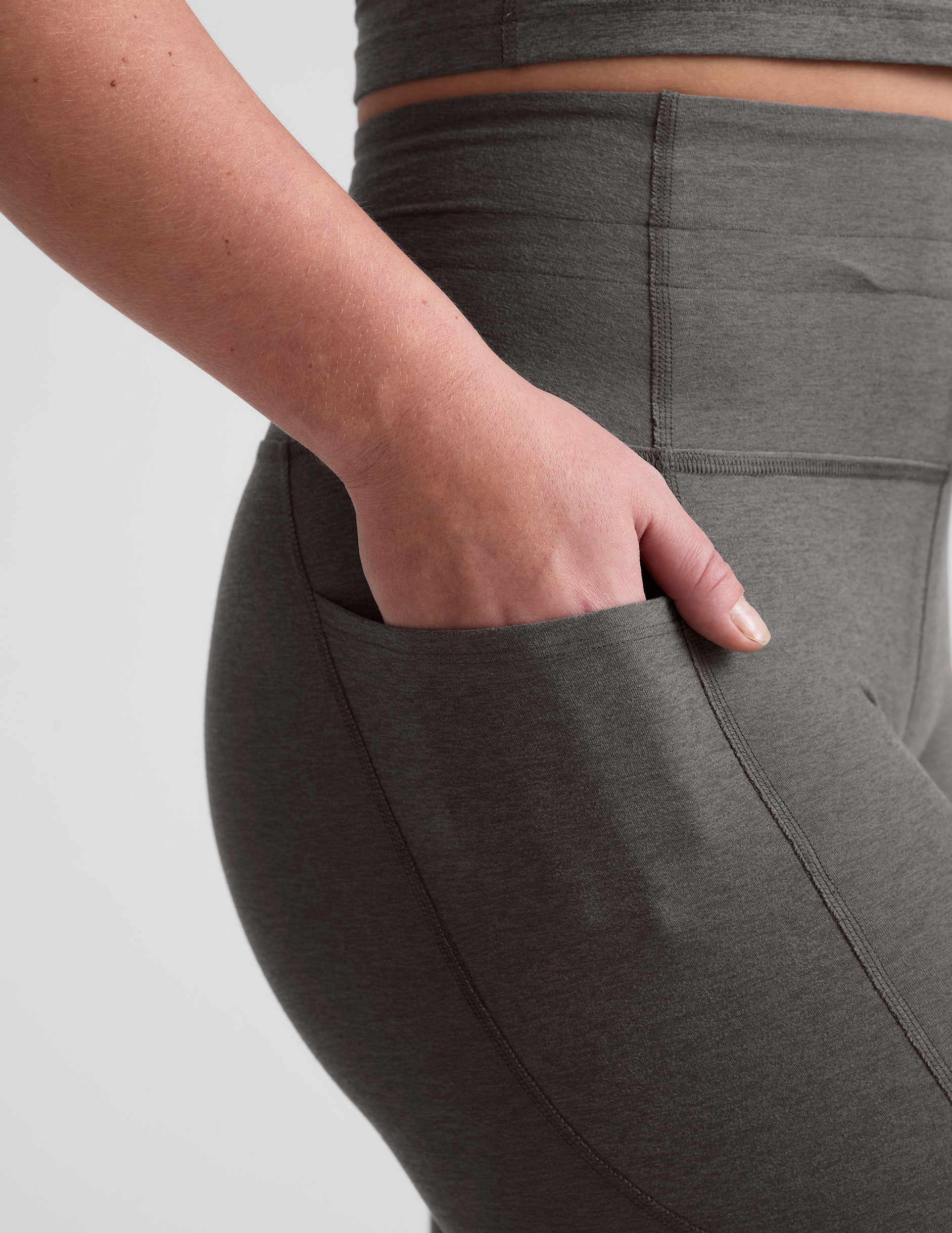 gray high-waisted midi length leggings with a drawstring at waistband and side pockets.