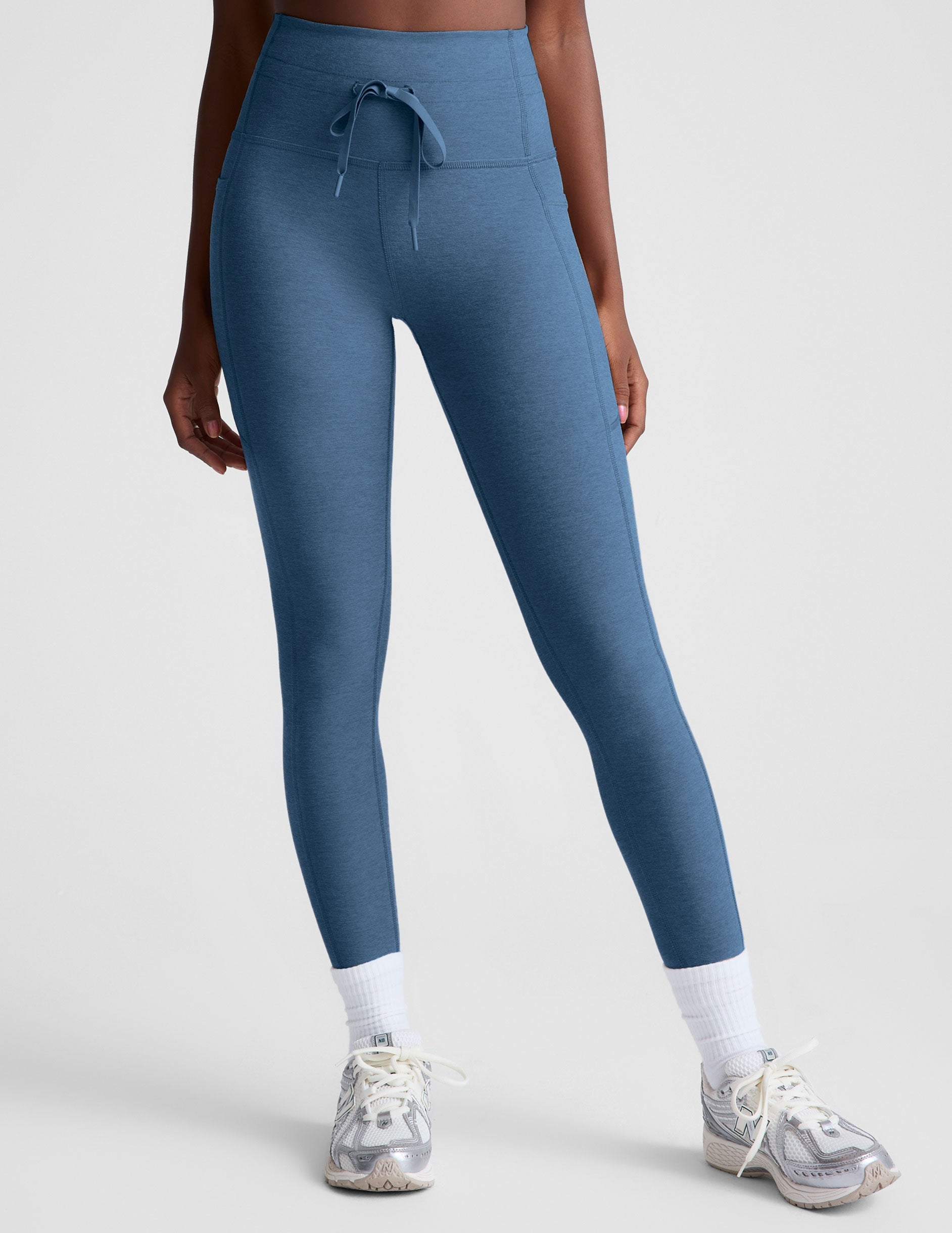 blue high-waisted midi leggings with pockets and a drawstring at waistband.