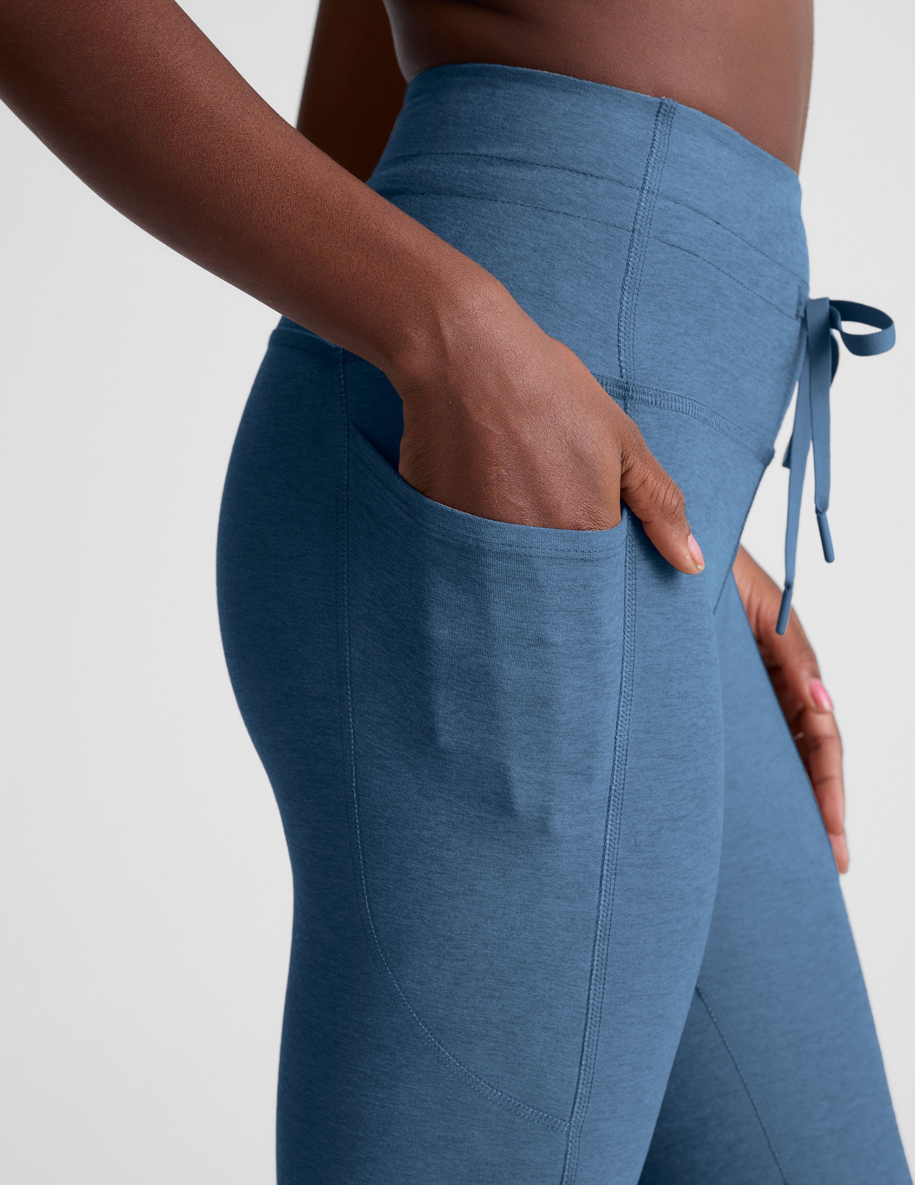blue high-waisted midi leggings with pockets and a drawstring at waistband.
