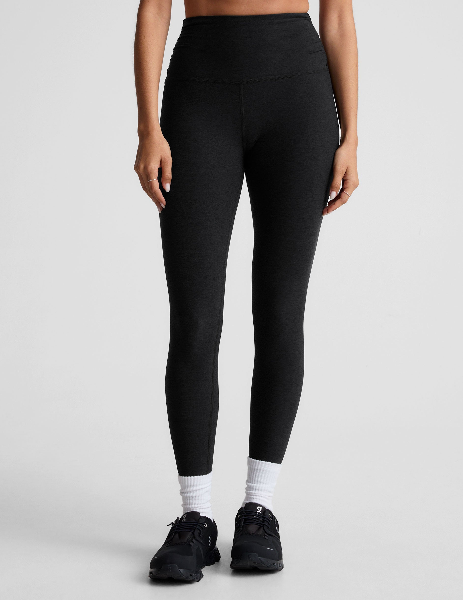 black high-waisted midi length legging with a shirred detail on the sides of the waistband.
