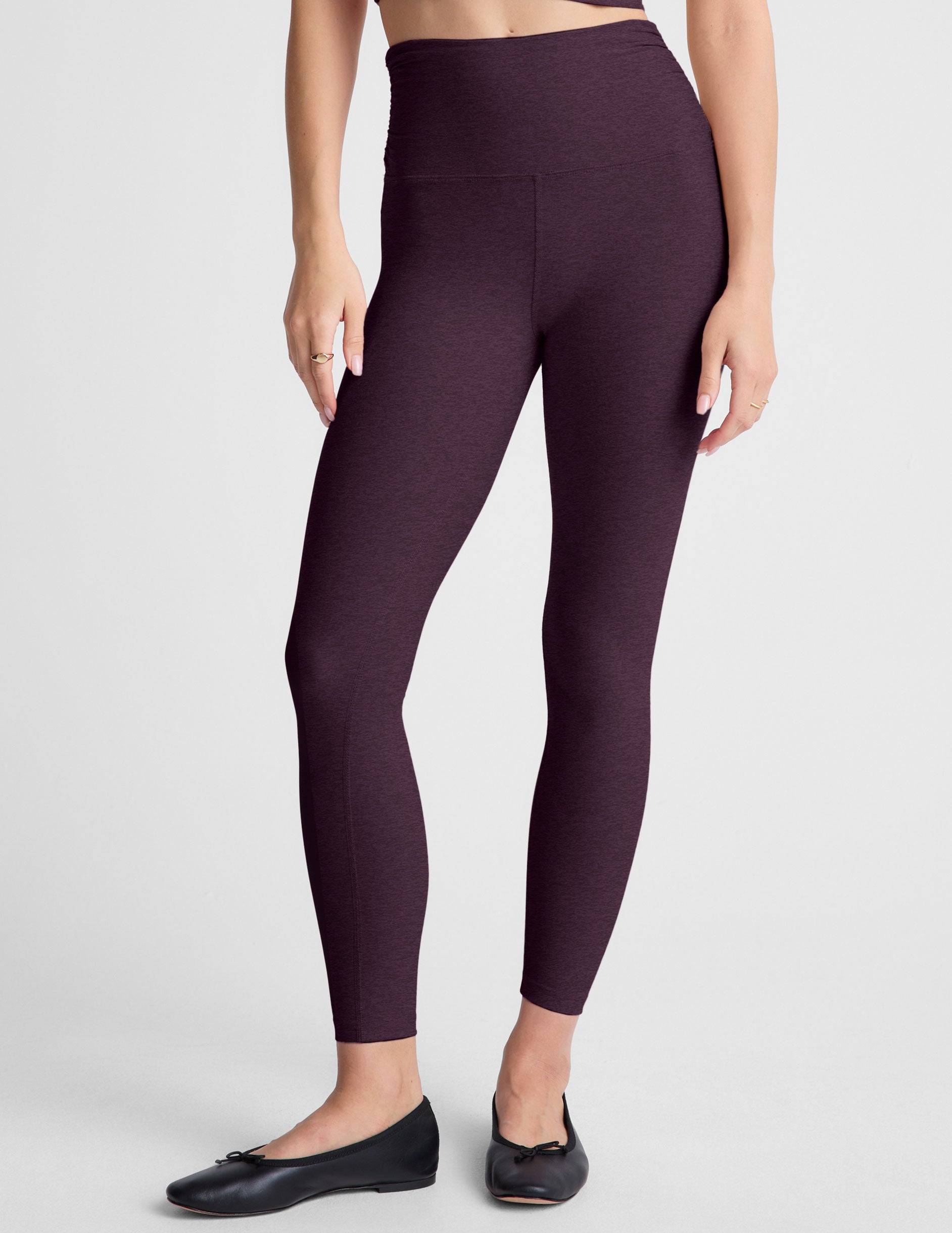 purple high-waisted midi length leggings against a plain background.