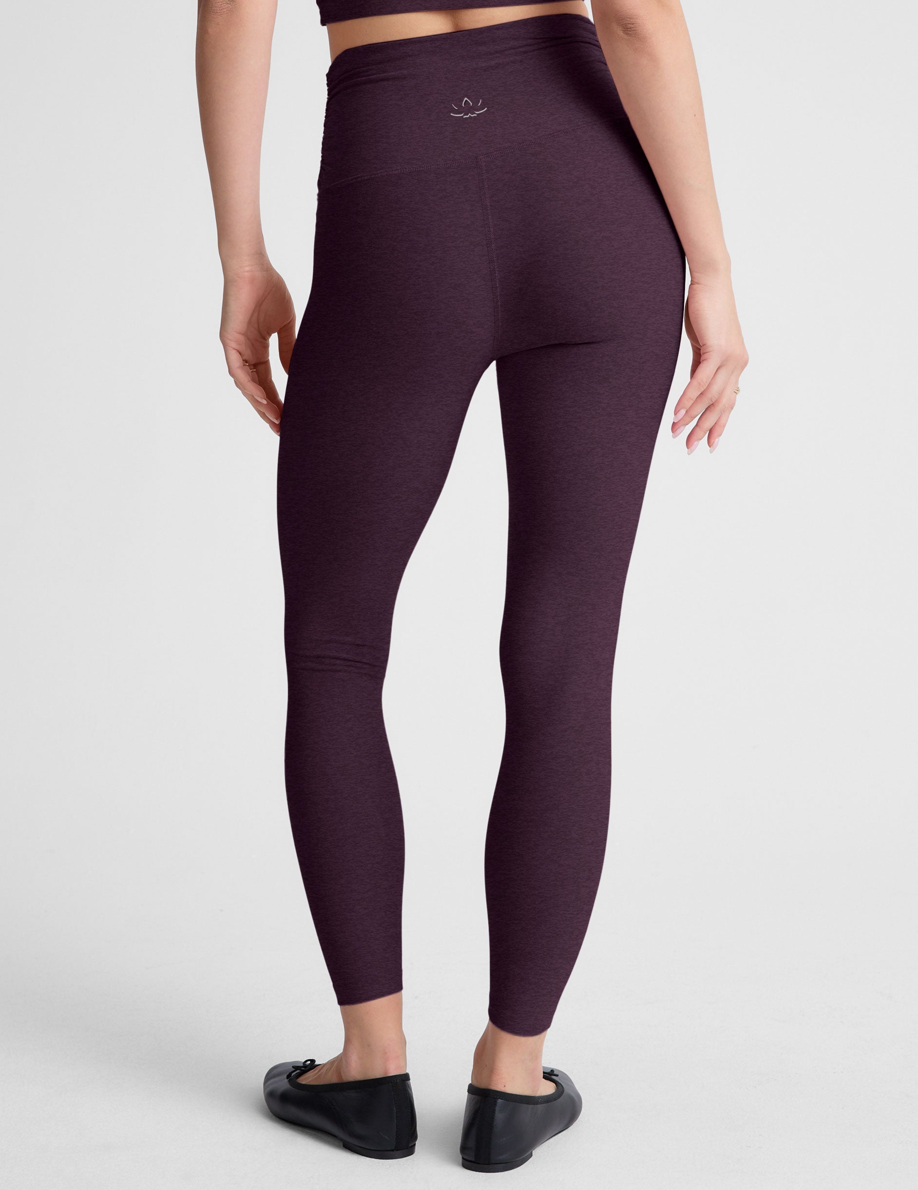 purple high-waisted midi length leggings against a plain background.