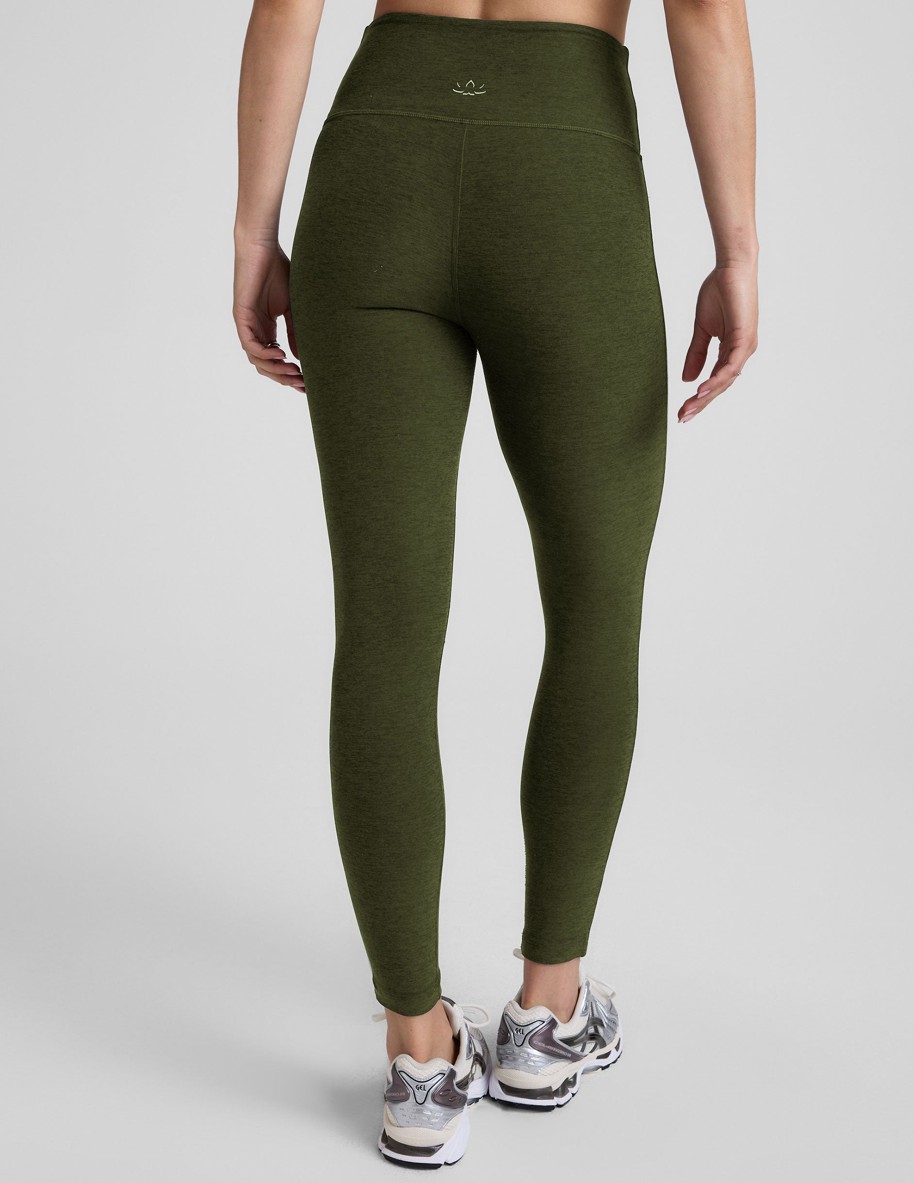 green high-waisted midi length leggings with white piping along sides.