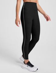 black high-waisted midi length leggings with white contrast piping at sides.