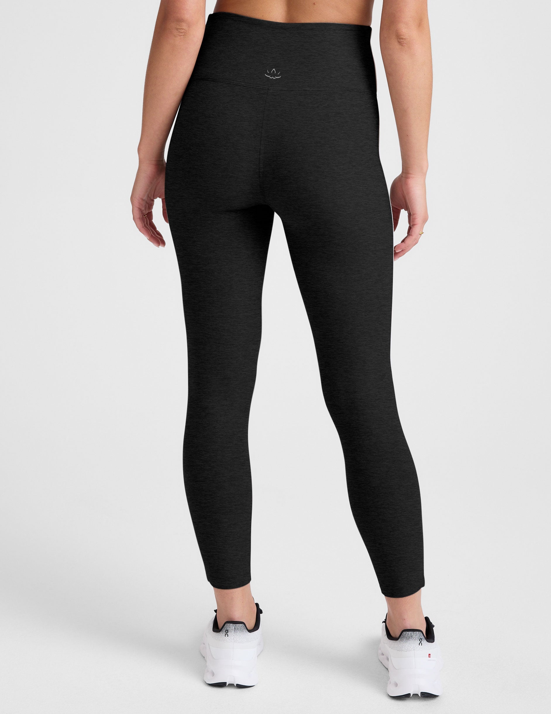 black high-waisted midi length leggings with white contrast piping at sides.