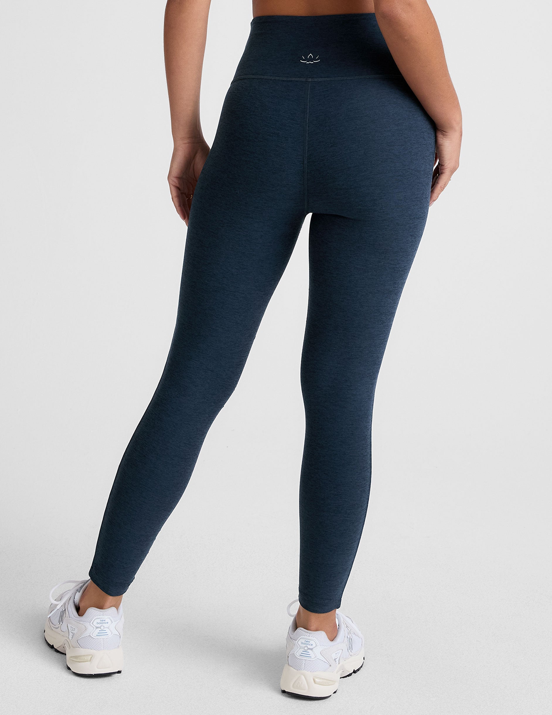 blue high-waisted midi length leggings with white piping on the side.
