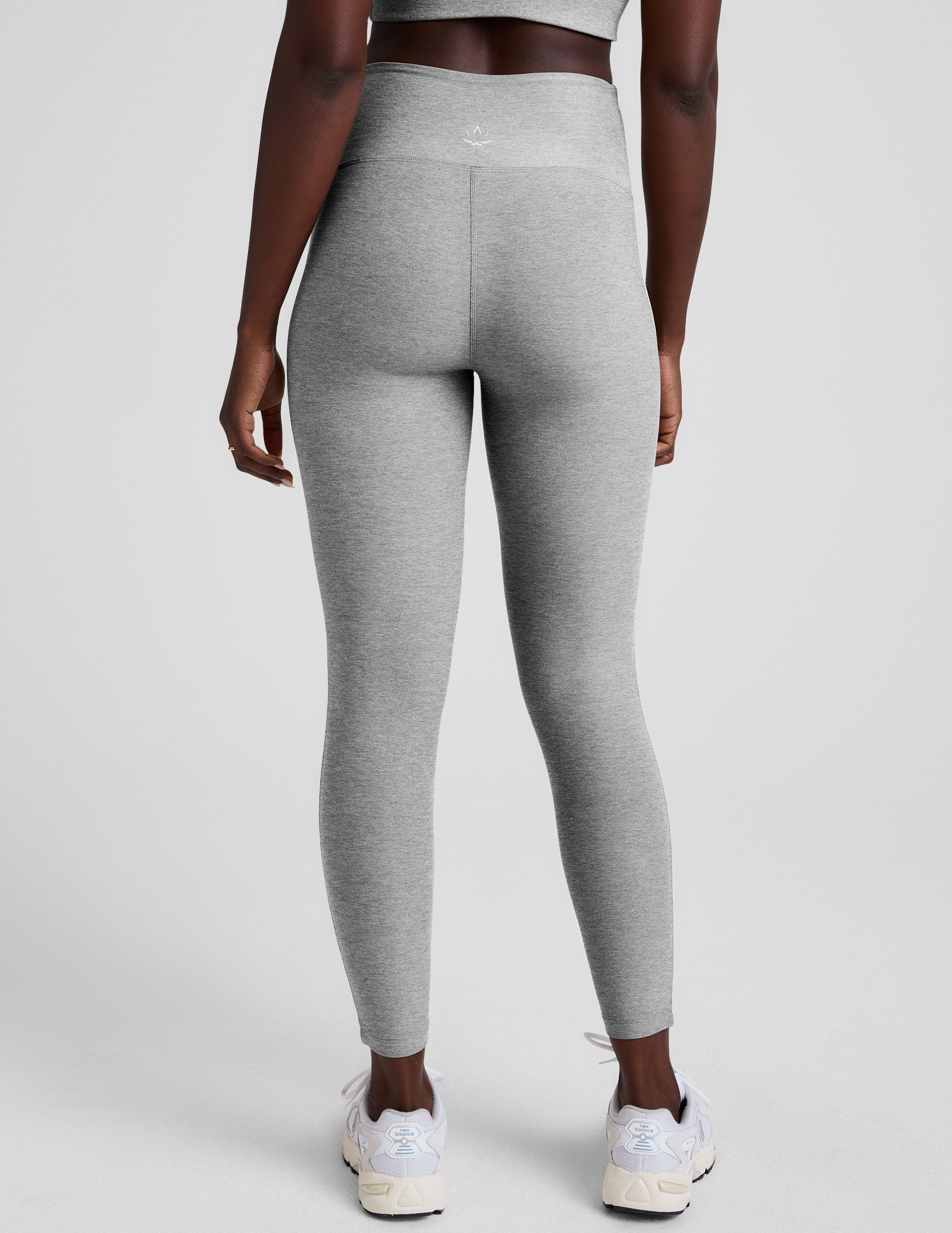 grey high-waisted midi length leggings with white piping details on sides.