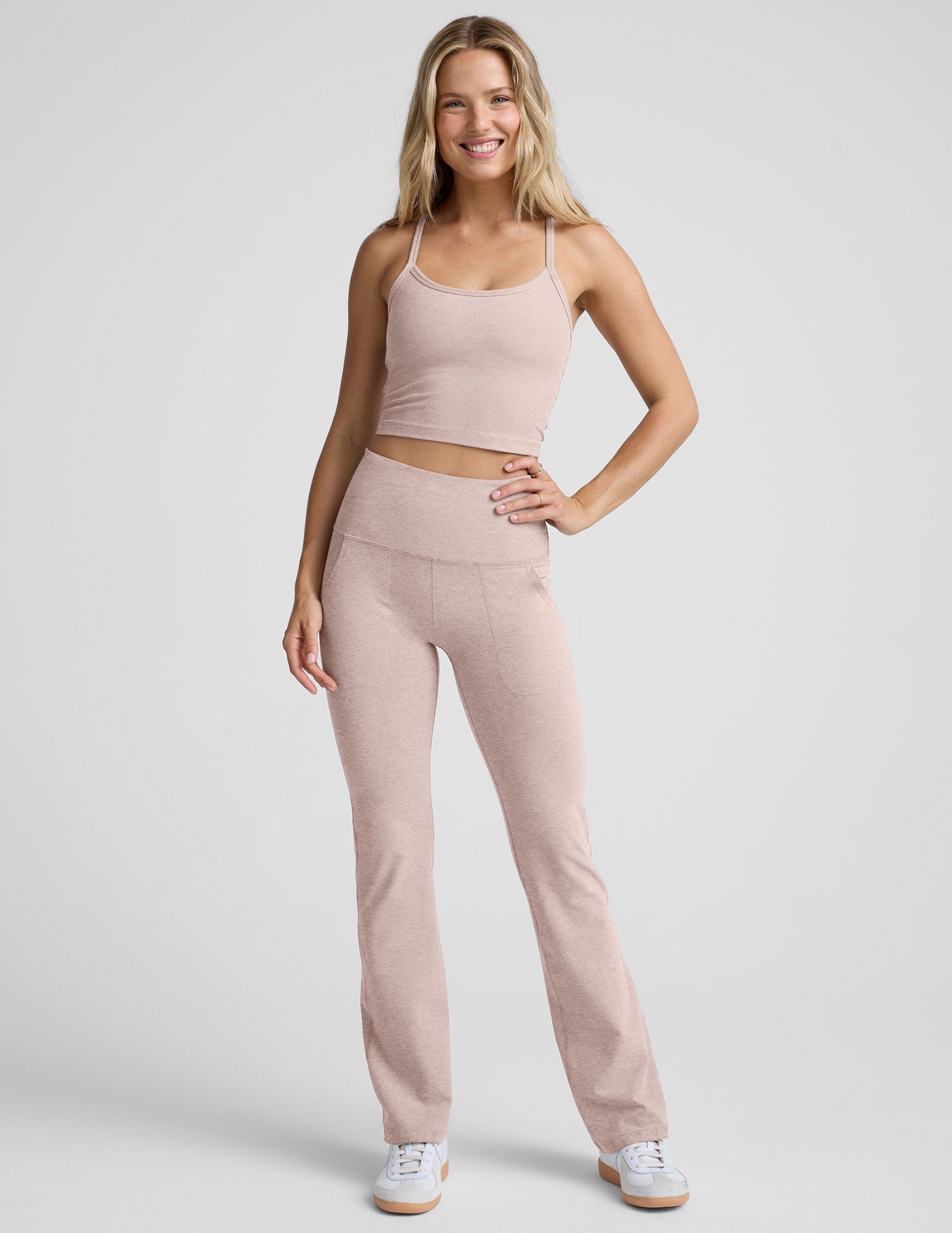 pink slim racerback cropped tank top and pink high-waisted midi leggings on a plain background.