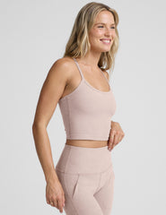 pink slim racerback cropped tank top and pink high-waisted midi leggings on a plain background.
