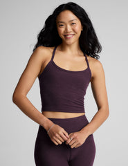 purple slim racerback cropped tank top and purple leggings on a plain background.