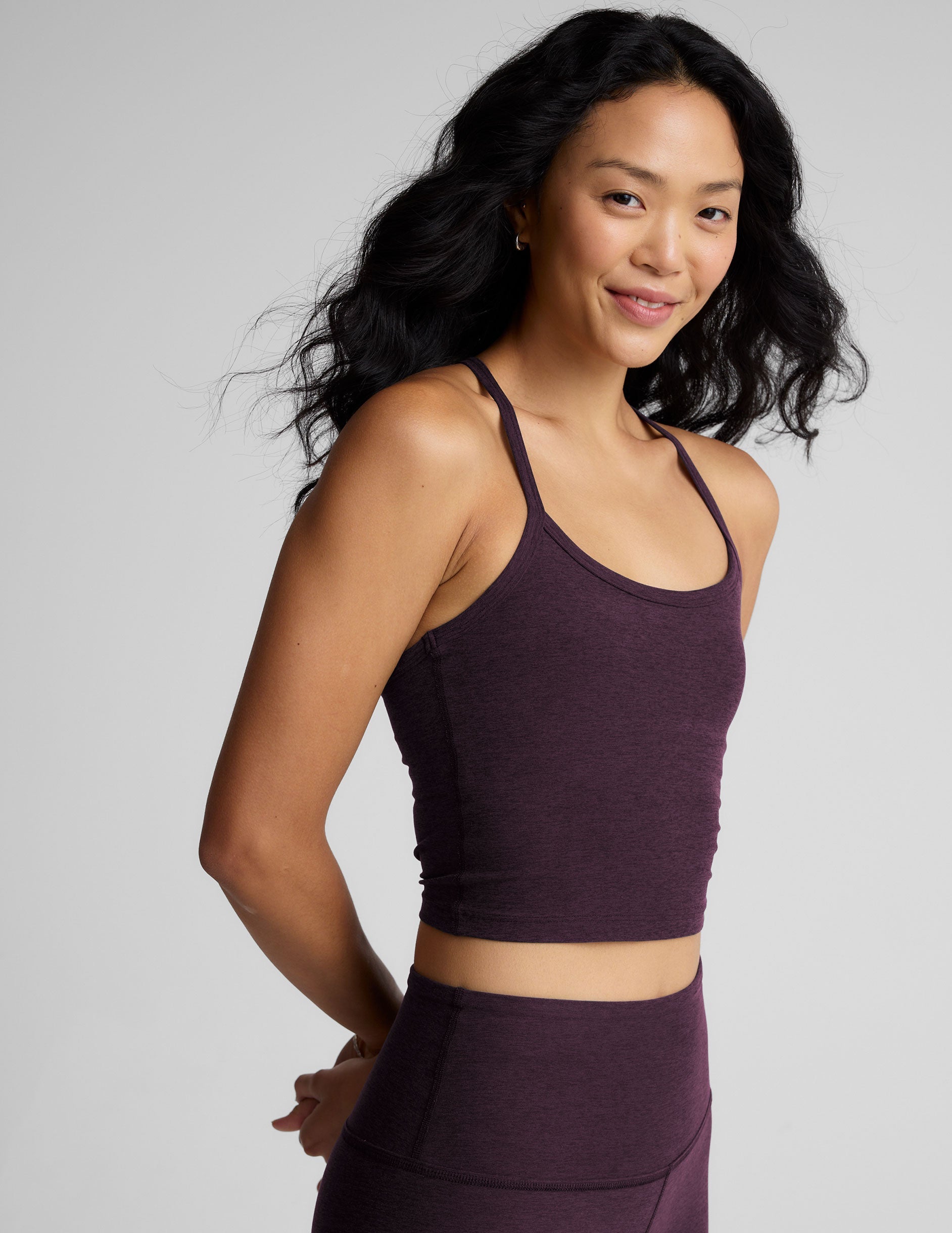 purple slim racerback cropped tank top and purple leggings on a plain background.