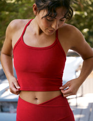 woman wearing a red slim racerback cropped tank and leggings outdoors.