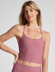 model wearing a pink racerback cropped tank top against a plain background.