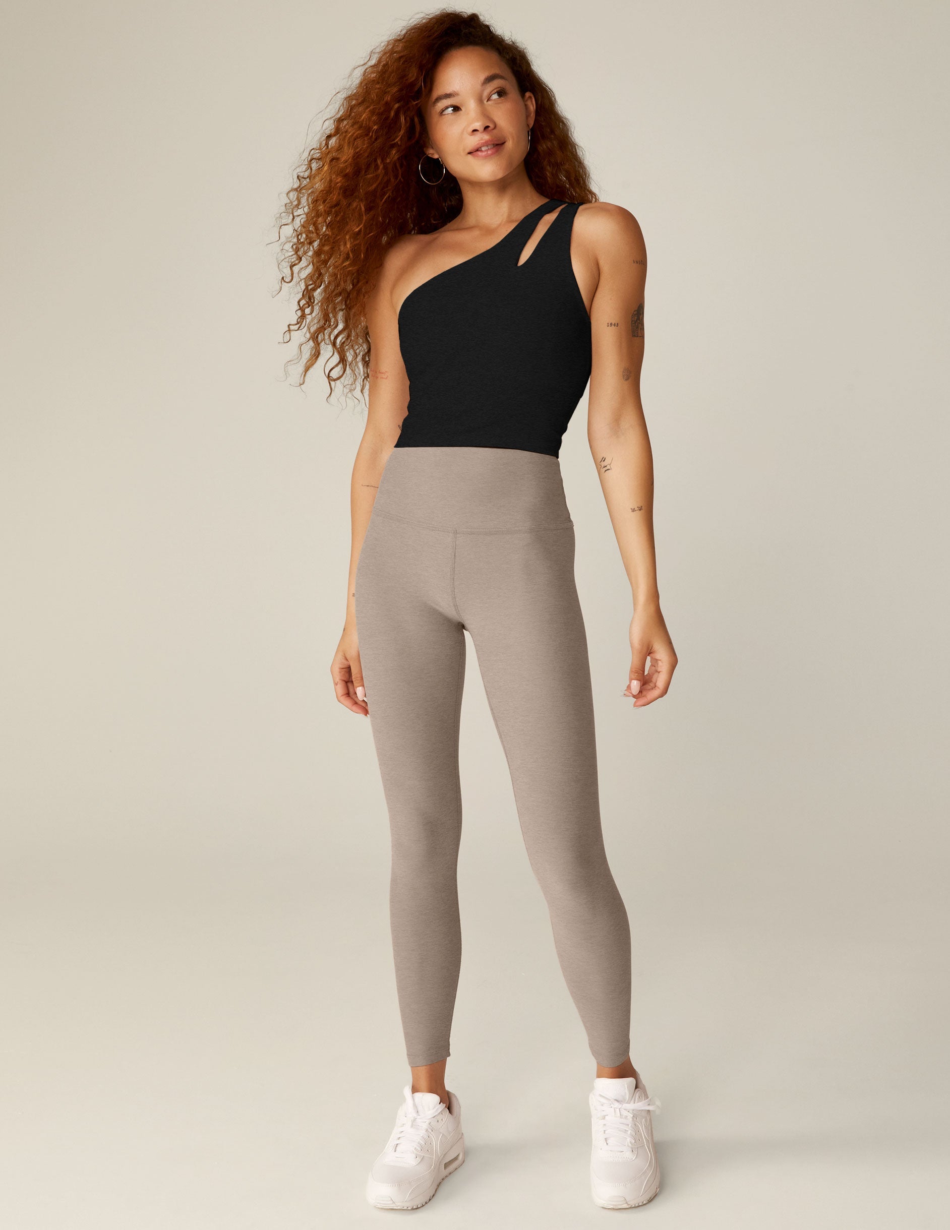 black one-shoulder cropped tank with a cutout on the front strap and a detailing on the back strap.