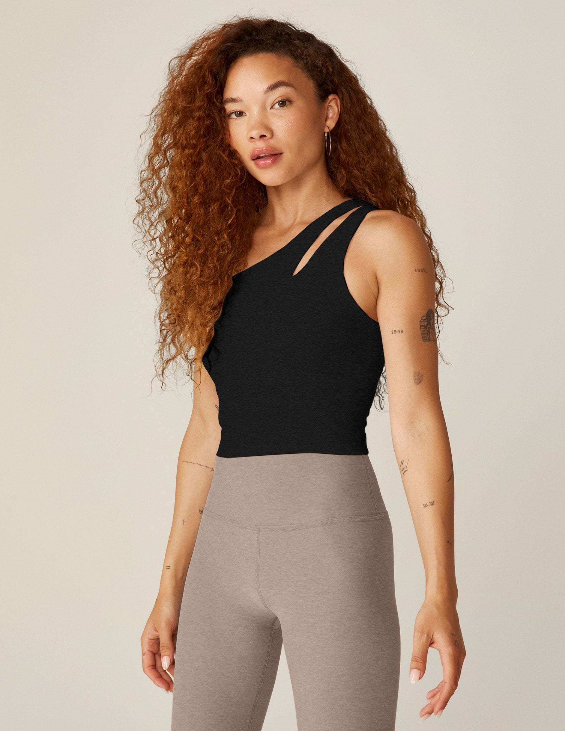black one-shoulder cropped tank with a cutout on the front strap and a detailing on the back strap.