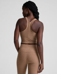 woman wearing a brown high neck racerback cropped tank top and leggings on a plain background.