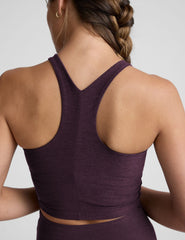 model wearing a purple high neck racerback cropped tank top and purple high-waisted midi length leggings against a plain background.