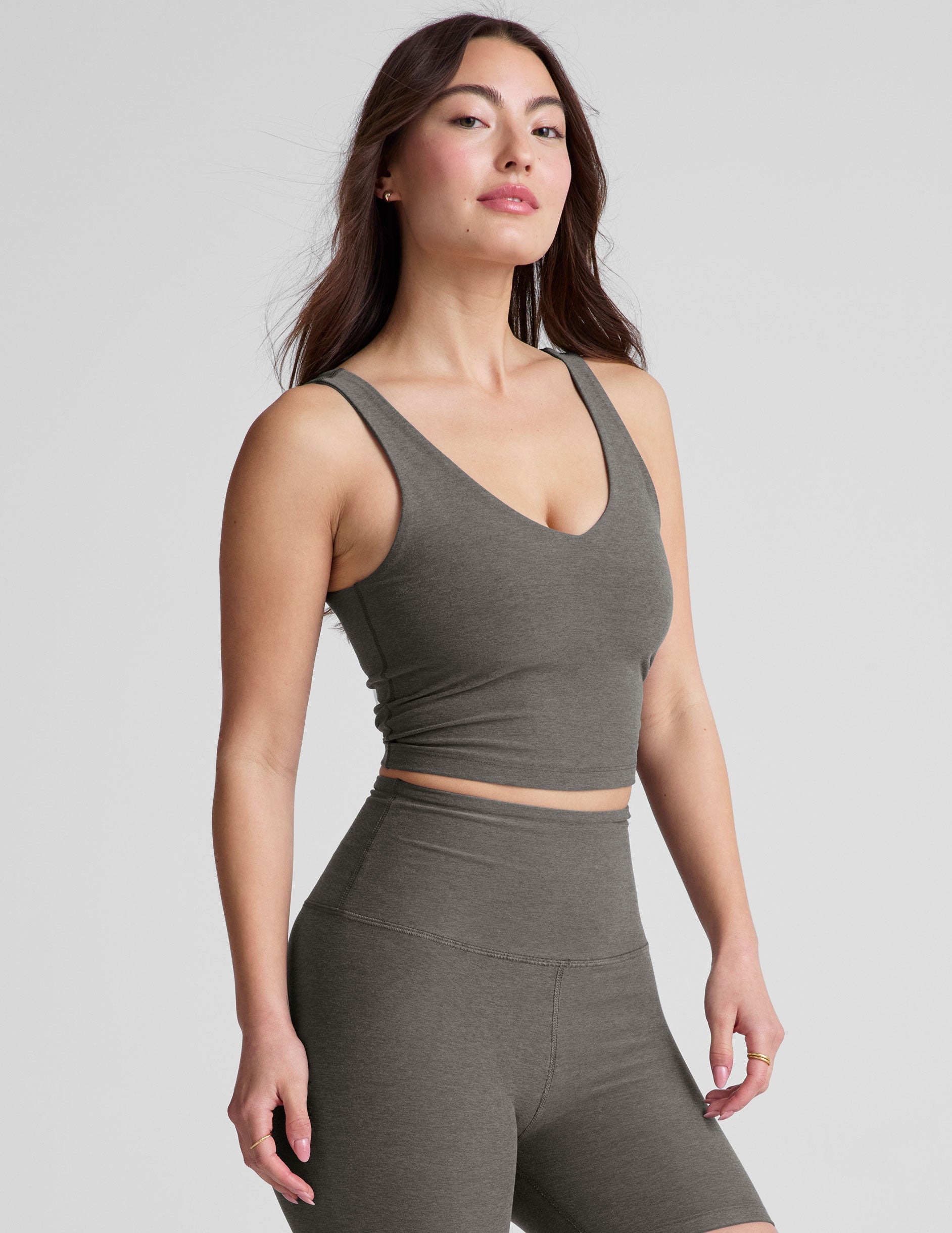 gray cropped length tank top with a front and back V neckline and self shelf bra. paired with high-waisted 5" inseam length biker shorts. 