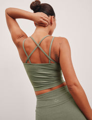 green waist length tank top with a v-neck and overlapping strap detail on back.