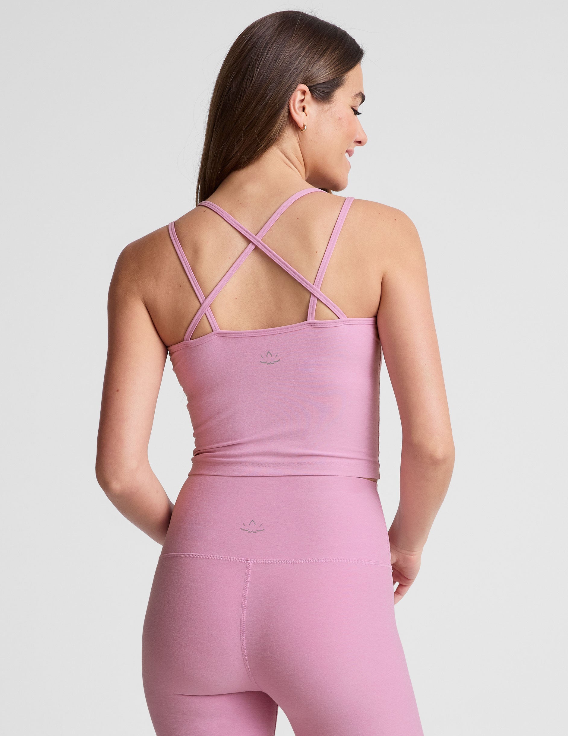 pink waist length, V neckline​ tank top with a self shelf bra and criss-cross strap back detail​. 