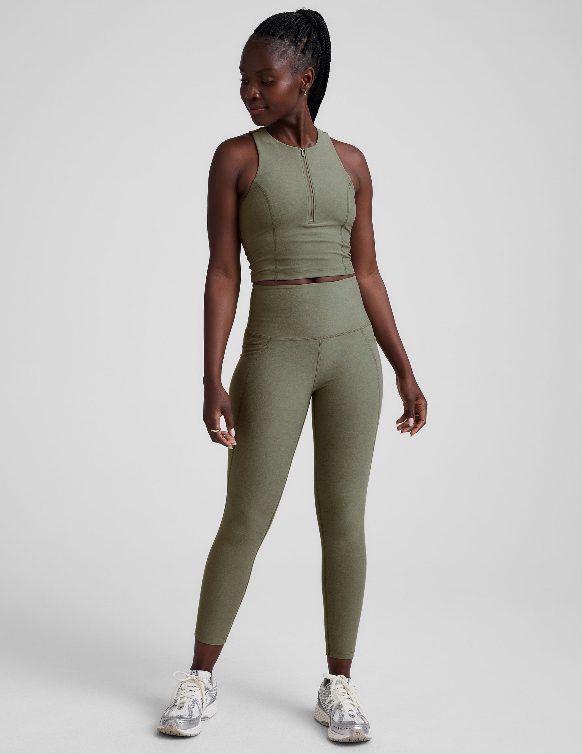 full body image of a green racerback cropped tank with a half zip up detail in front.