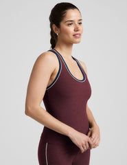 model wearing a maroon tank top with navy and white trim on a light gray background.
