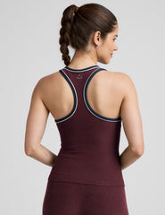 model wearing a maroon tank top with navy and white trim on a light gray background.