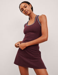 model wearing a maroon tank top with navy and white trim on a light gray background.