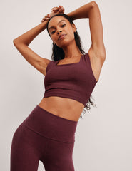model is wearing a cropped square neck tank with thick straps.