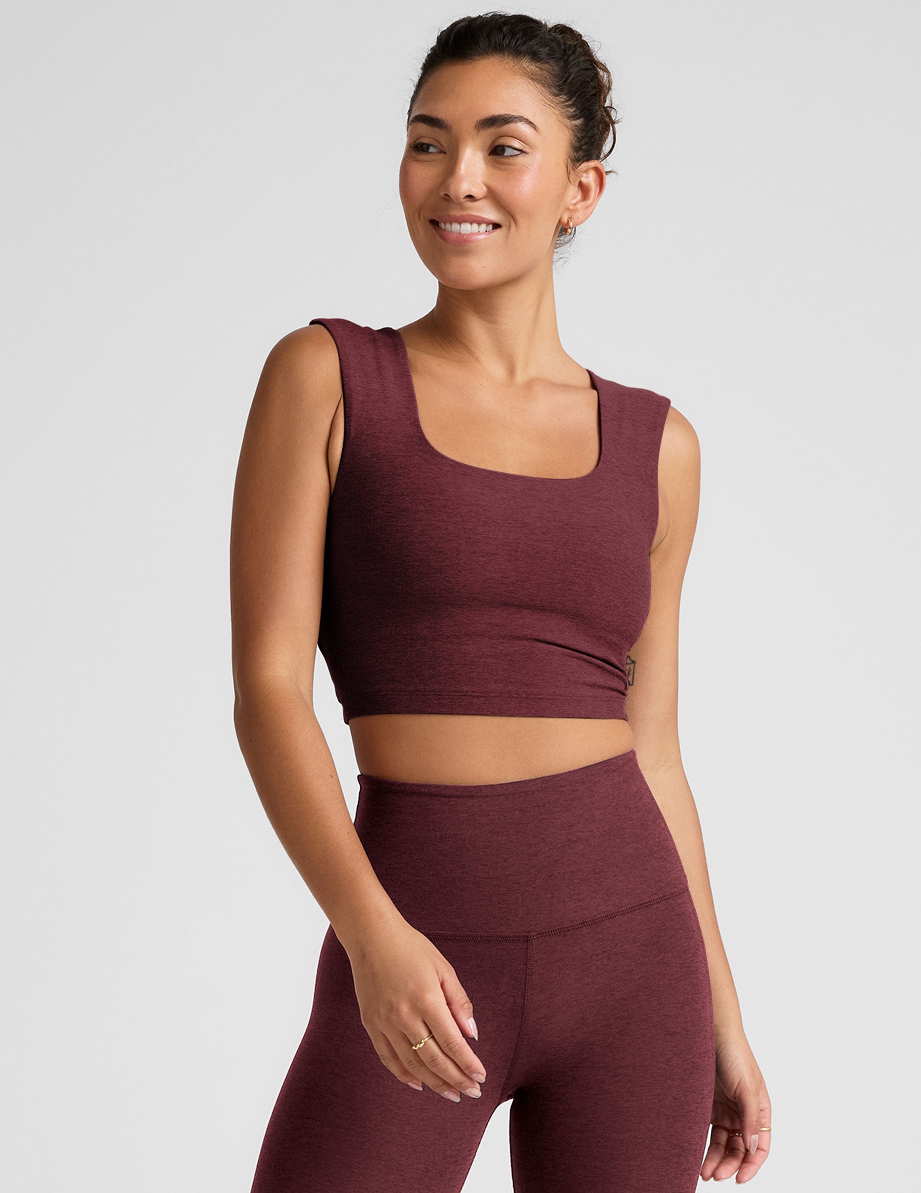 model is wearing a cropped square neck tank with thick straps.