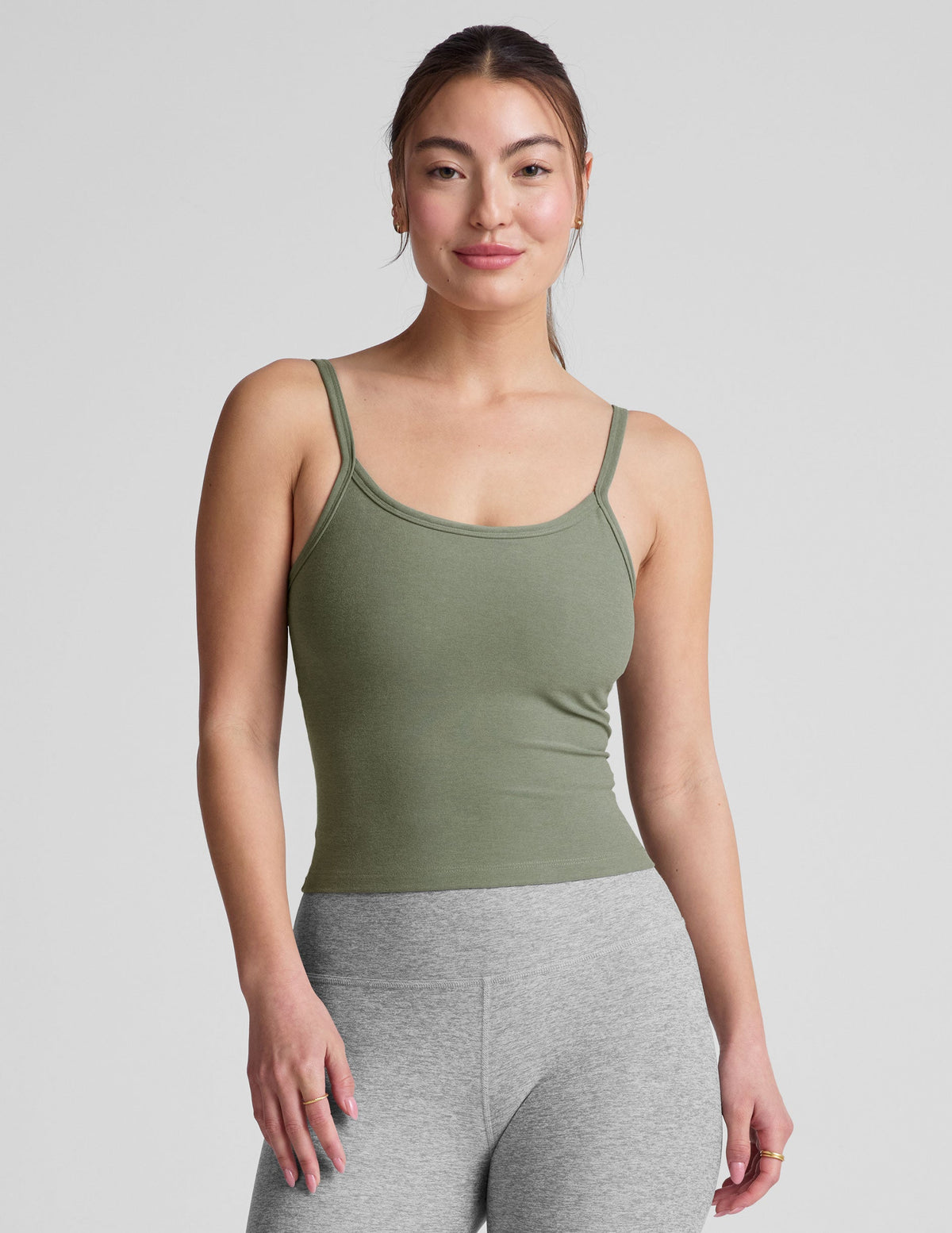 green waist length tank top with adjustable straps.