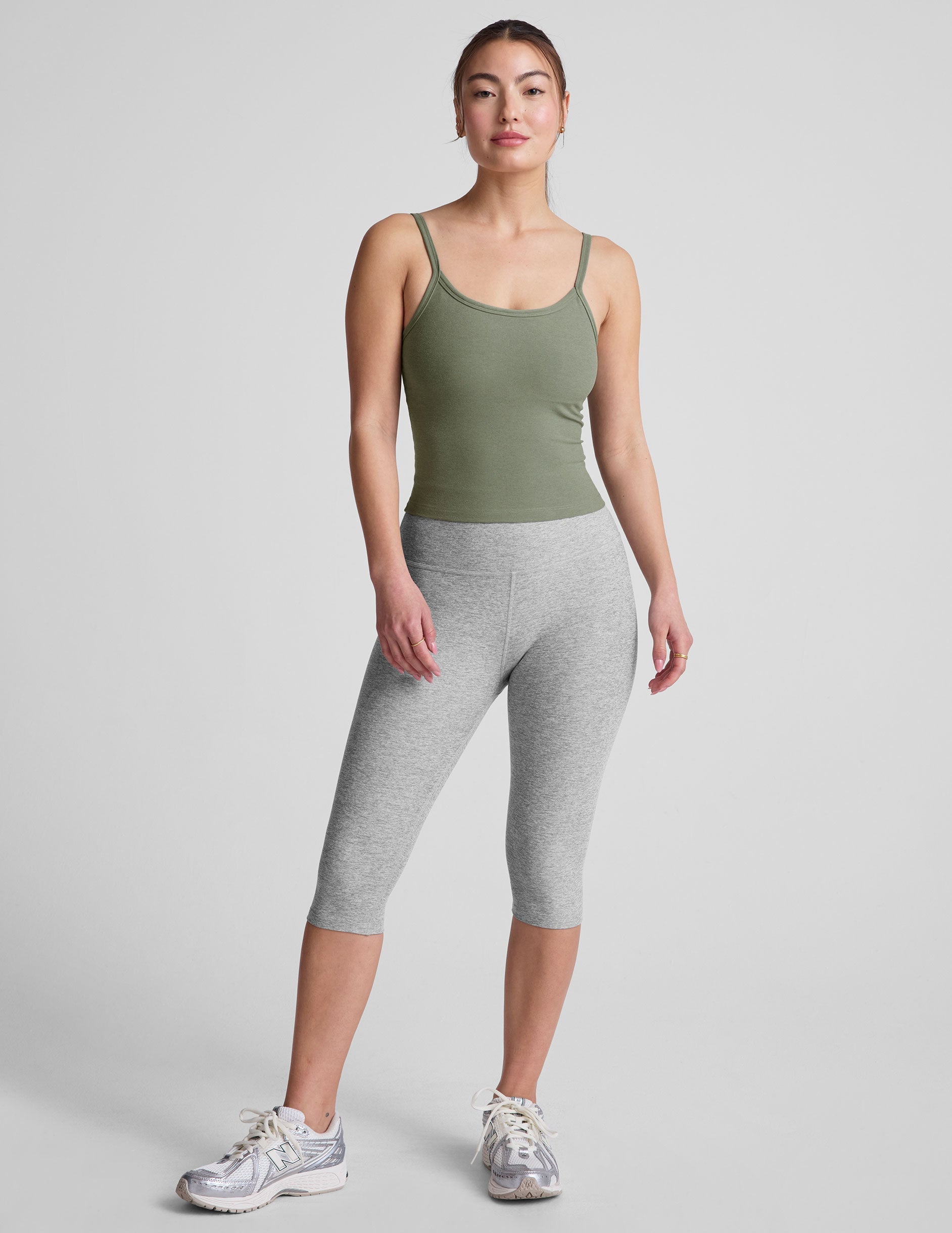 green waist length tank top with adjustable straps.