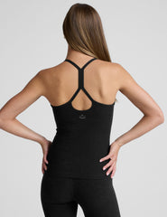woman wearing a full length racerback tank top and leggings against a plain background.