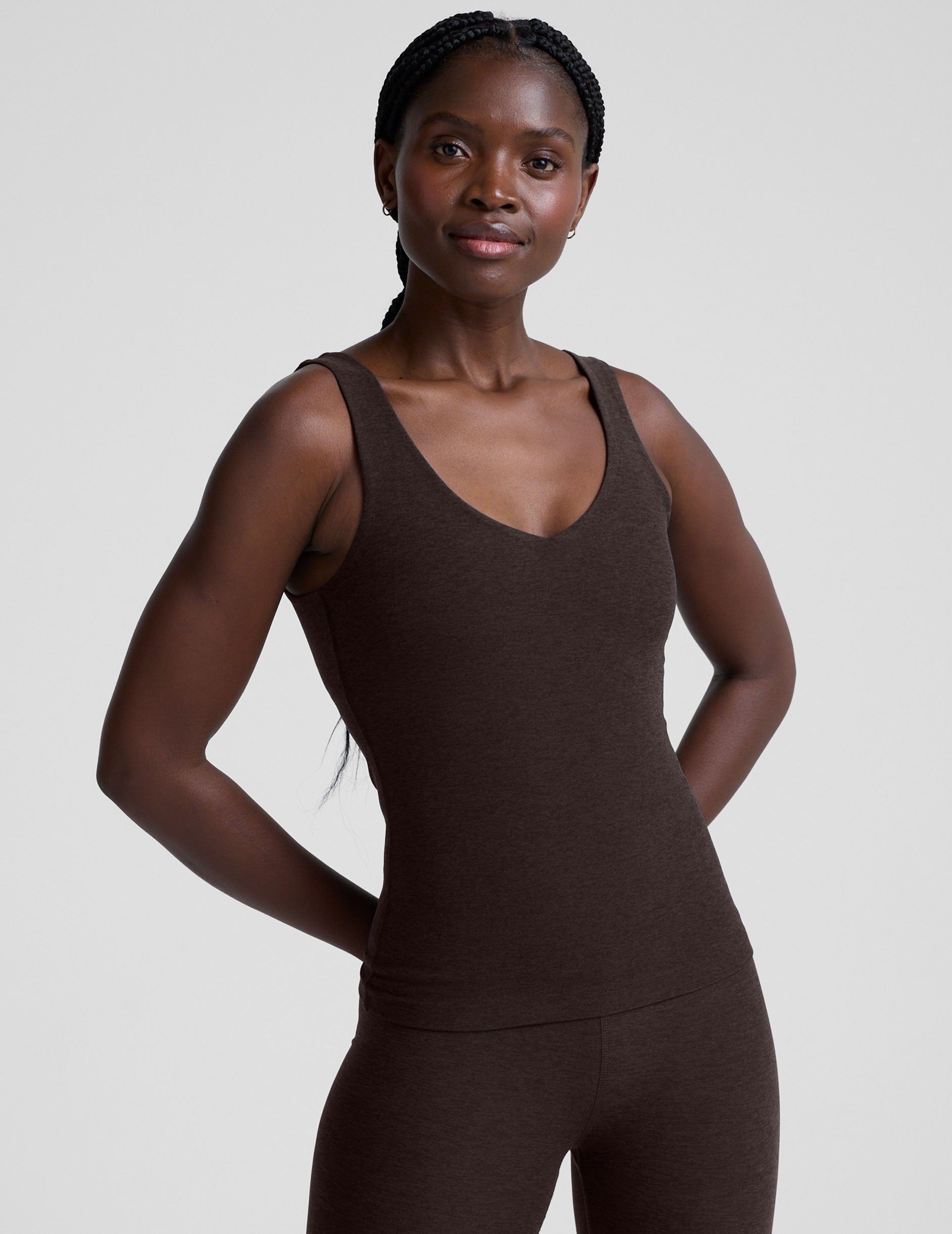 model wearing a brown full length tank top and leggings against a plain background.