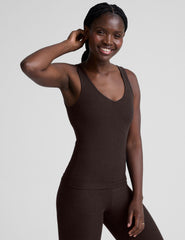 model wearing a brown full length tank top and leggings against a plain background.