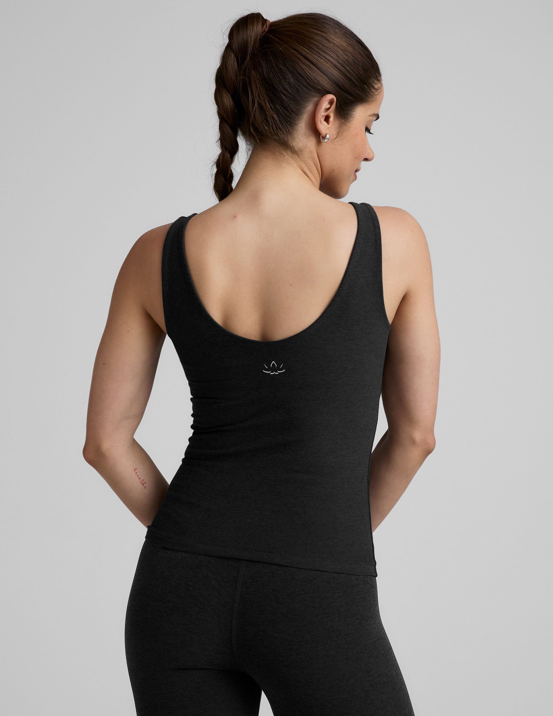 black waist length tank top with a front and back v neckline.