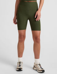 model is wearing green high-waisted 7" inseam biker shorts. 